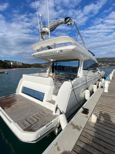  Yacht Photos Pics Luxury 2023 Prestige 520 yacht docked at marina under blue sky.