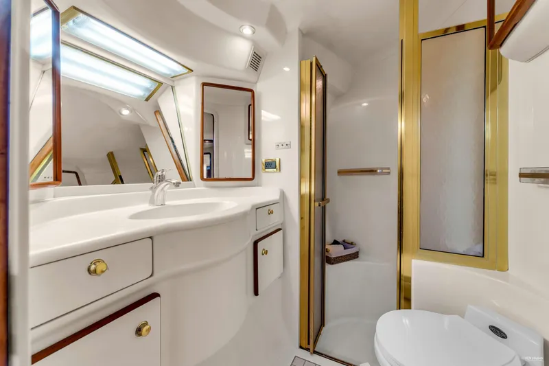  Yacht Photos Pics Luxurious bathroom in 1997 Sea Ray 500 Sundancer yacht with gold accents and modern fixtures.