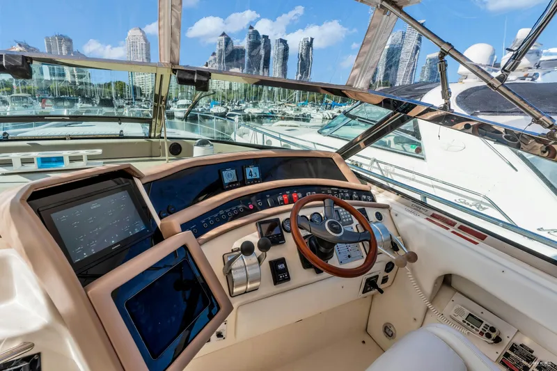  Yacht Photos Pics Cockpit view of 1997 Sea Ray 500 Sundancer yacht with city skyline in background.
