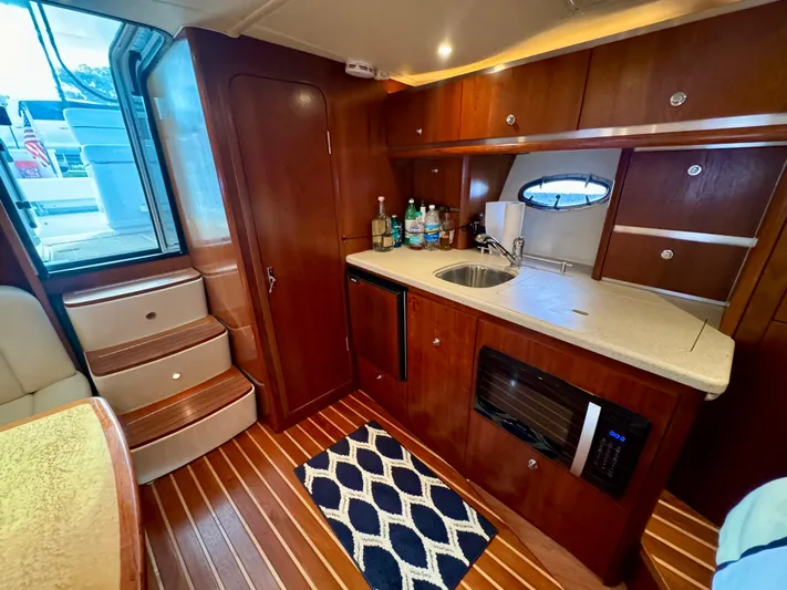  Yacht Photos Pics 2006 Tiara Yachts 3200 Open interior with kitchenette, wooden cabinetry, and modern amenities.