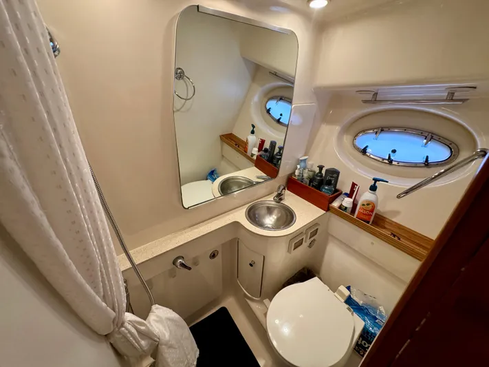  Yacht Photos Pics Bathroom interior of 2006 Tiara Yachts 3200 Open, featuring sink, mirror, and porthole window.