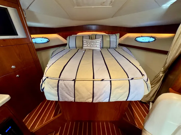  Yacht Photos Pics Luxurious cabin interior of 2006 Tiara Yachts 3200 Open with striped bedding.