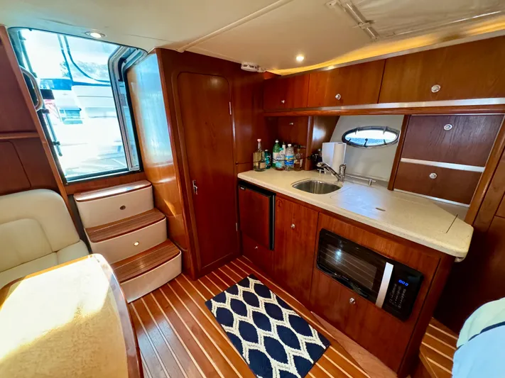  Yacht Photos Pics 2006 Tiara Yachts 3200 Open interior with kitchenette, wooden cabinetry, and modern appliances.