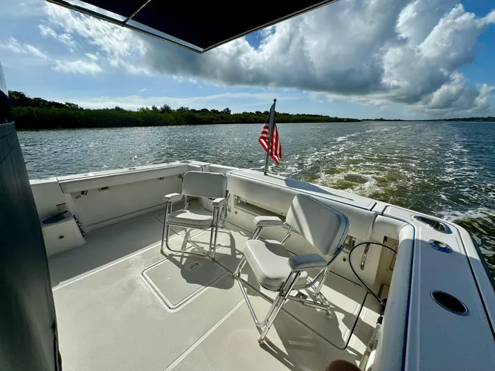  Yacht Photos Pics 2006 Tiara Yachts 3200 Open cruising with chairs and American flag on deck.