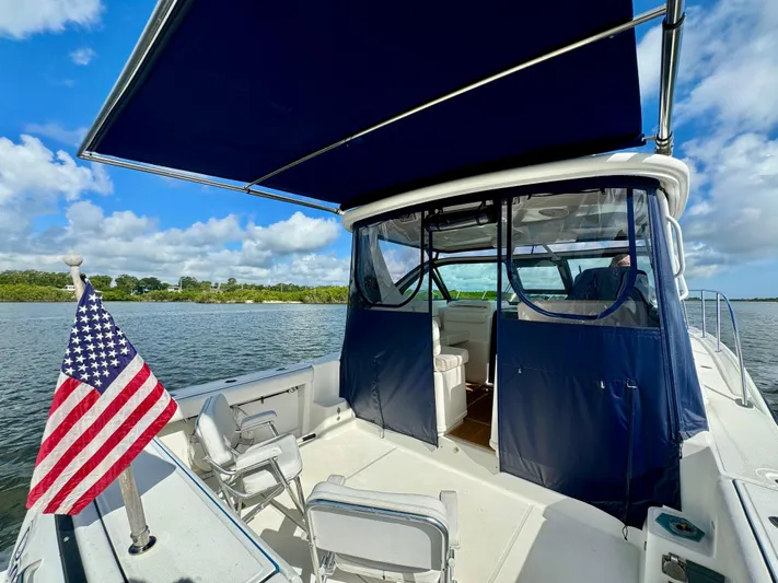  Yacht Photos Pics 2006 Tiara Yachts 3200 Open with American flag, blue canopy, and scenic water view.