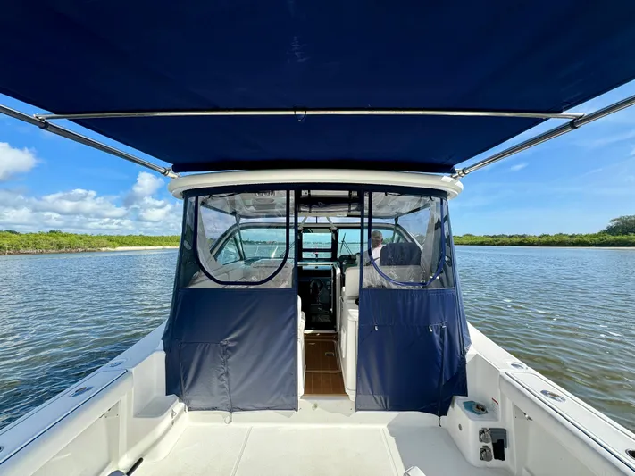  Yacht Photos Pics 2006 Tiara Yachts 3200 Open on calm water with blue canopy and clear skies.