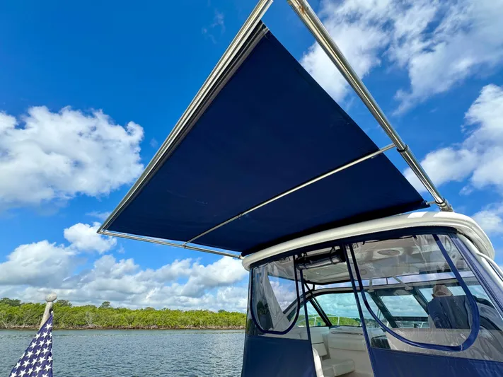  Yacht Photos Pics 2006 Tiara Yachts 3200 Open with blue canopy under clear sky.