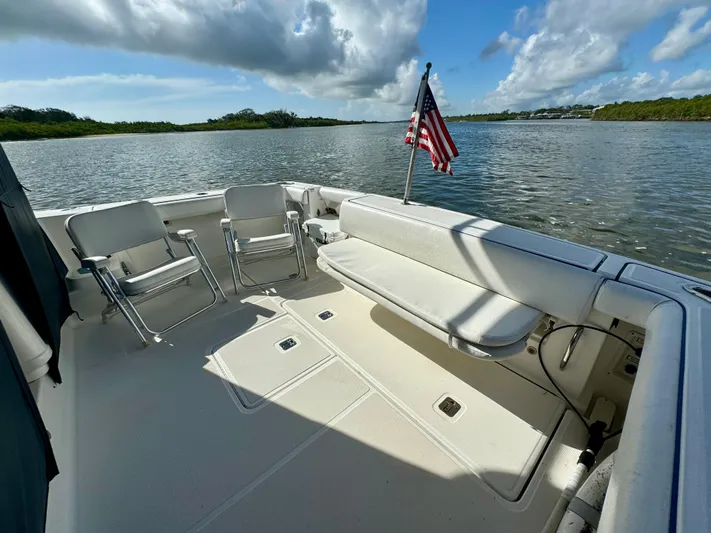  Yacht Photos Pics 2006 Tiara Yachts 3200 Open boat deck with seating and American flag on calm water.