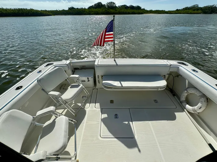  Yacht Photos Pics 2006 Tiara Yachts 3200 Open boat deck with chairs and American flag on water.