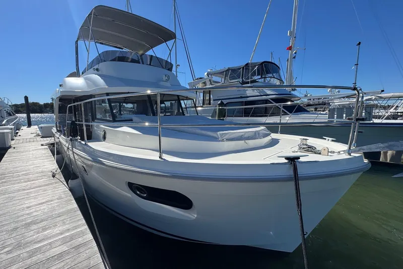 R&r Yacht Photos Pics 2023 Beneteau Swift Trawler 35 docked at marina under clear blue sky.