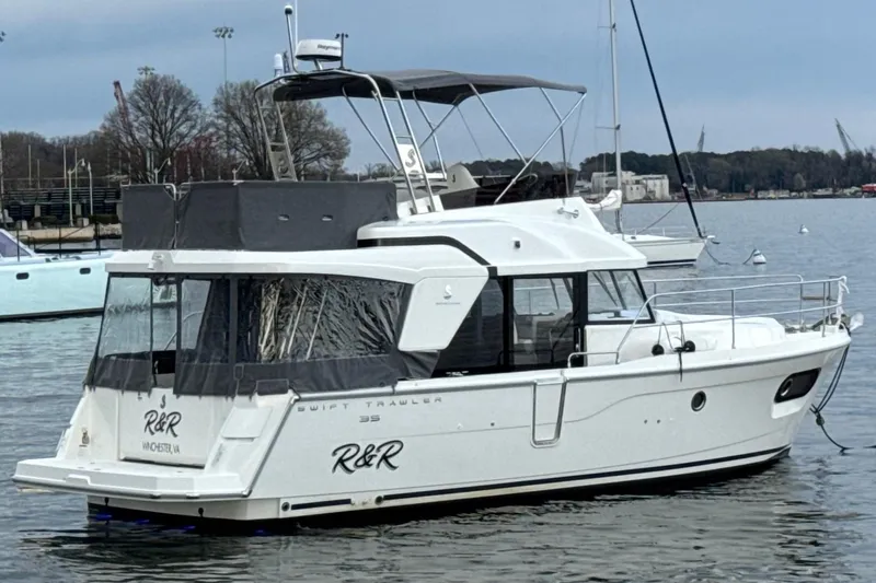 R&r Yacht Photos Pics 2023 Beneteau Swift Trawler 35 yacht on calm water, side view.