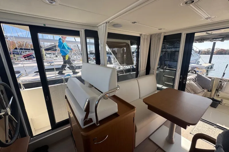 R&r Yacht Photos Pics Interior of 2023 Beneteau Swift Trawler 35 with seating and table, dockside view.