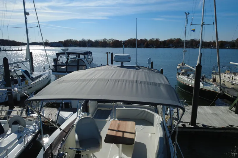 R&r Yacht Photos Pics 2023 Beneteau Swift Trawler 35 docked at marina, surrounded by sailboats.