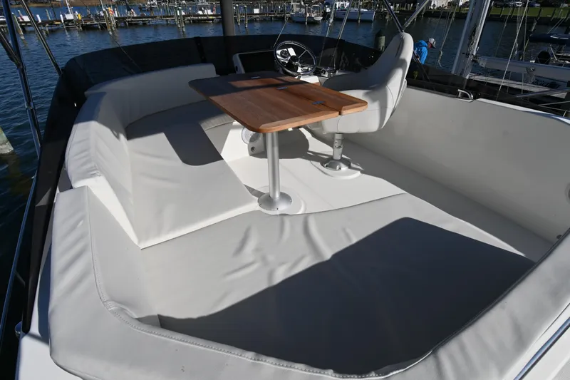 R&r Yacht Photos Pics 2023 Beneteau Swift Trawler 35 flybridge with seating and wooden table, docked at marina.
