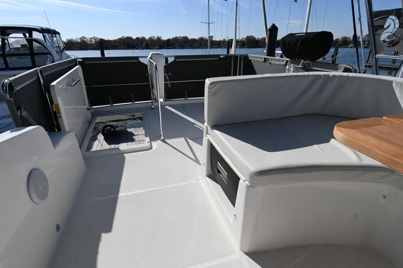 R&r Yacht Photos Pics 2023 Beneteau Swift Trawler 35 deck with seating and open hatch, docked by the water.