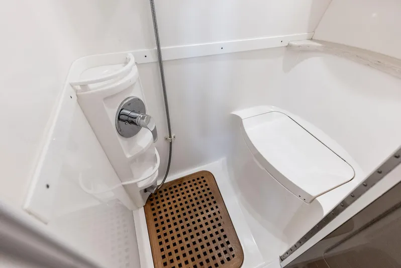 Virgo Yacht Photos Pics 2018 Intrepid 430 Sport Yacht bathroom with shower, wooden floor mat, and white fixtures.