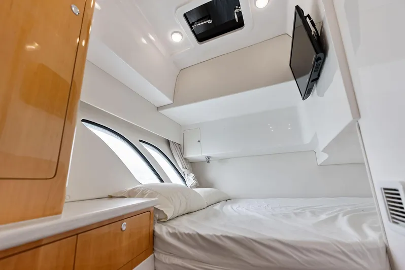 Virgo Yacht Photos Pics 2018 Intrepid 430 Sport Yacht cabin interior with bed, TV, and porthole windows.