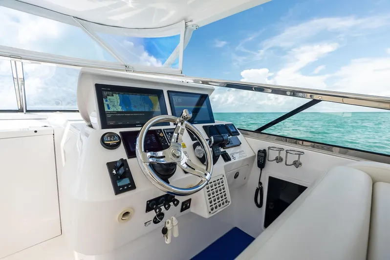 Virgo Yacht Photos Pics Cockpit of 2018 Intrepid 430 Sport Yacht with navigation screens and steering wheel, ocean view.