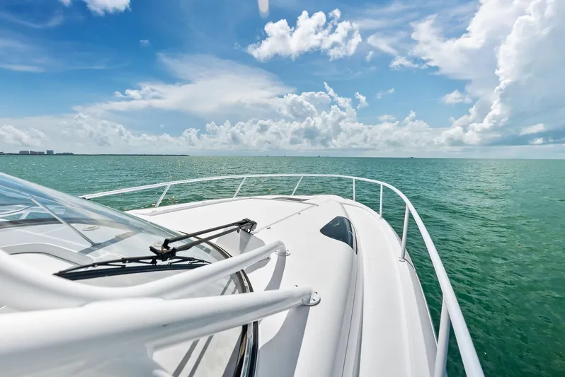 Virgo Yacht Photos Pics 2018 Intrepid 430 Sport Yacht cruising on clear blue ocean under a bright sky.