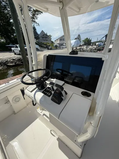  Yacht Photos Pics 2018 Jupiter 26 FS boat console with steering wheel and controls, docked near waterfront.