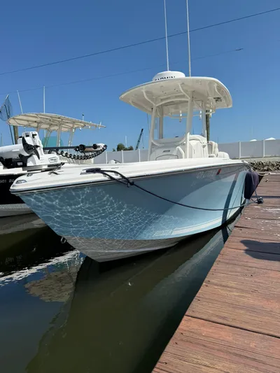  Yacht Photos Pics 2018 Jupiter 26 FS boat docked, reflecting sunlight on calm water.
