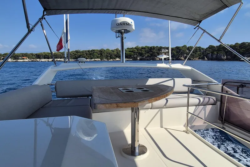  Yacht Photos Pics 2022 Prestige 460 yacht deck with seating, table, and ocean view.