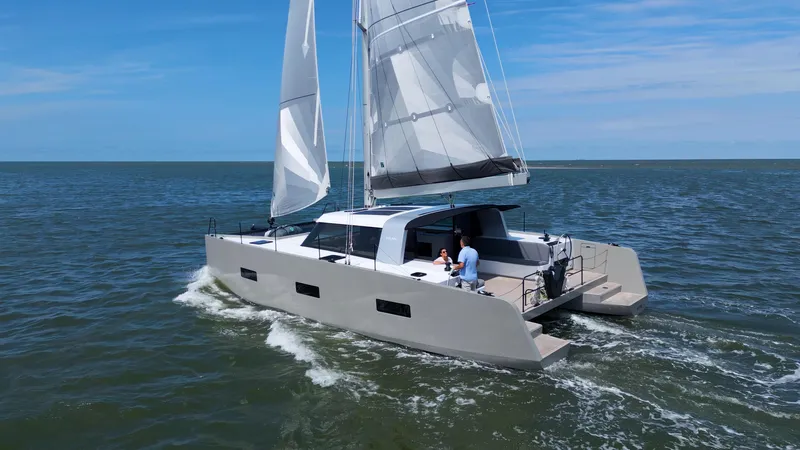  Yacht Photos Pics Sailing catamaran Vaan R4 2025 gliding on open sea under clear blue sky.