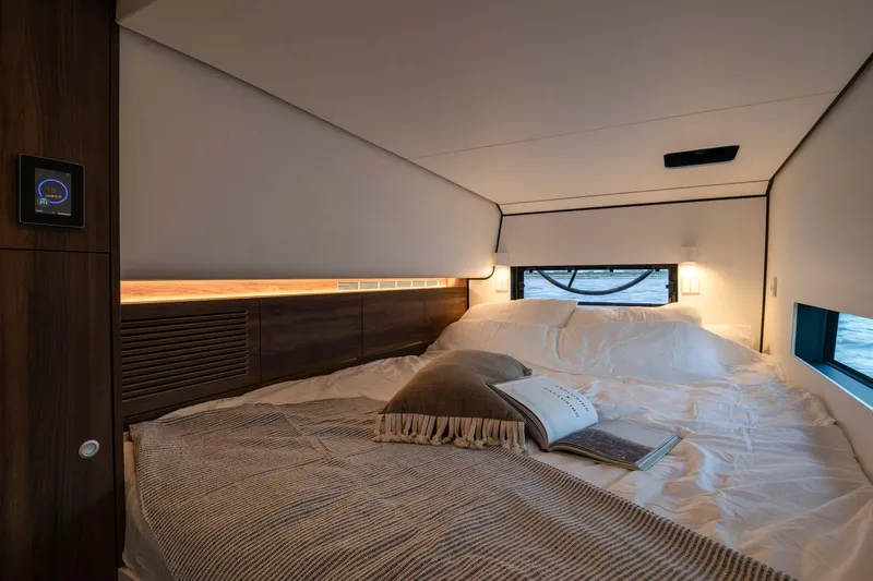  Yacht Photos Pics Luxurious interior of 2025 Vaan R4, featuring a cozy bed with elegant bedding and ambient lighting.