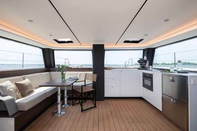  Yacht Photos Pics Luxurious interior of 2025 Vaan R4 yacht with modern kitchen and seating area.
