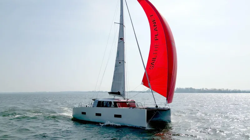  Yacht Photos Pics Sailing yacht Vaan R4 2025 with red sail on open water.