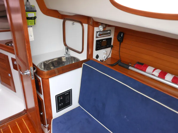 Ohana Lll Yacht Photos Pics 2009 Alerion Express 33 interior with sink, blue seating, and wooden accents.