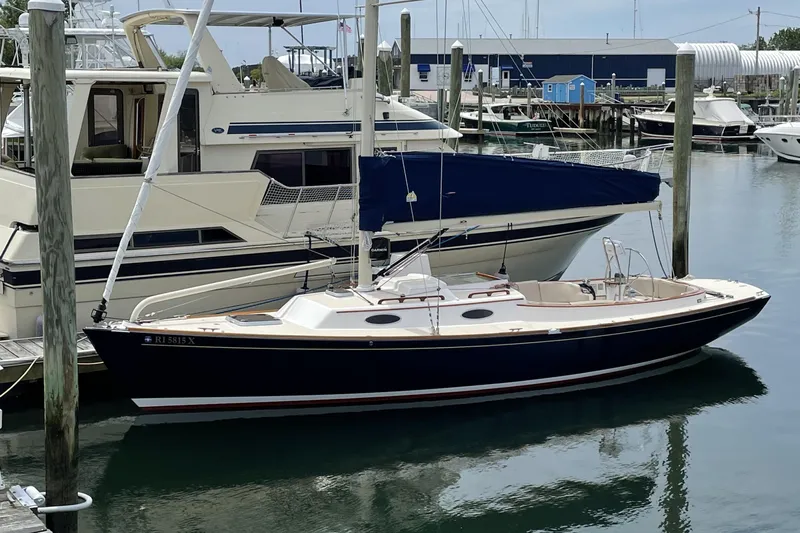 Ohana Lll Yacht Photos Pics 2009 Alerion Express 33 sailboat docked at a marina, alongside a larger yacht.