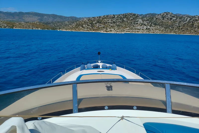  Yacht Photos Pics 2004 Sunseeker 82 Yacht cruising on blue waters with scenic coastal backdrop.