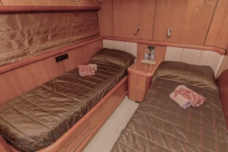  Yacht Photos Pics Twin cabin interior of 2004 Sunseeker 82 Yacht with brown bedding and wooden furnishings.