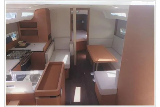  Yacht Photos Pics Interior of 2022 Jeanneau Sun Odyssey 410 yacht, featuring modern kitchen and seating area.
