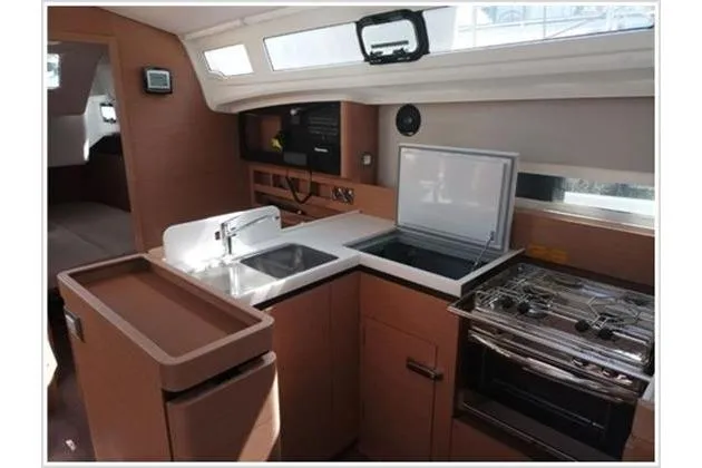  Yacht Photos Pics Modern kitchen interior of 2022 Jeanneau Sun Odyssey 410 yacht, featuring sink and stove.