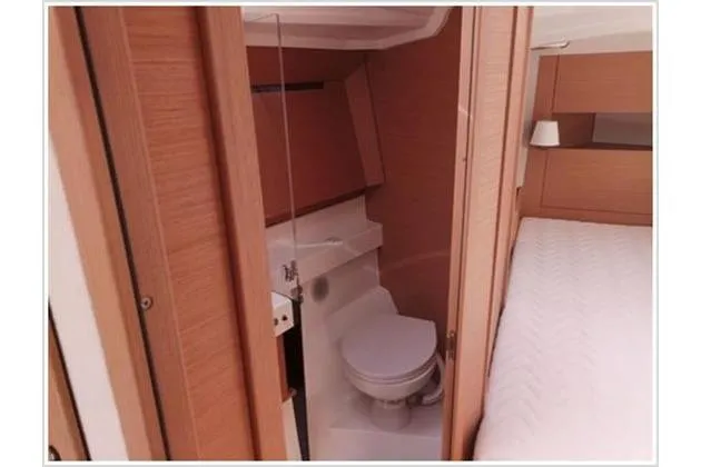  Yacht Photos Pics Interior of 2022 Jeanneau Sun Odyssey 410 yacht, featuring a compact bathroom and cozy cabin.