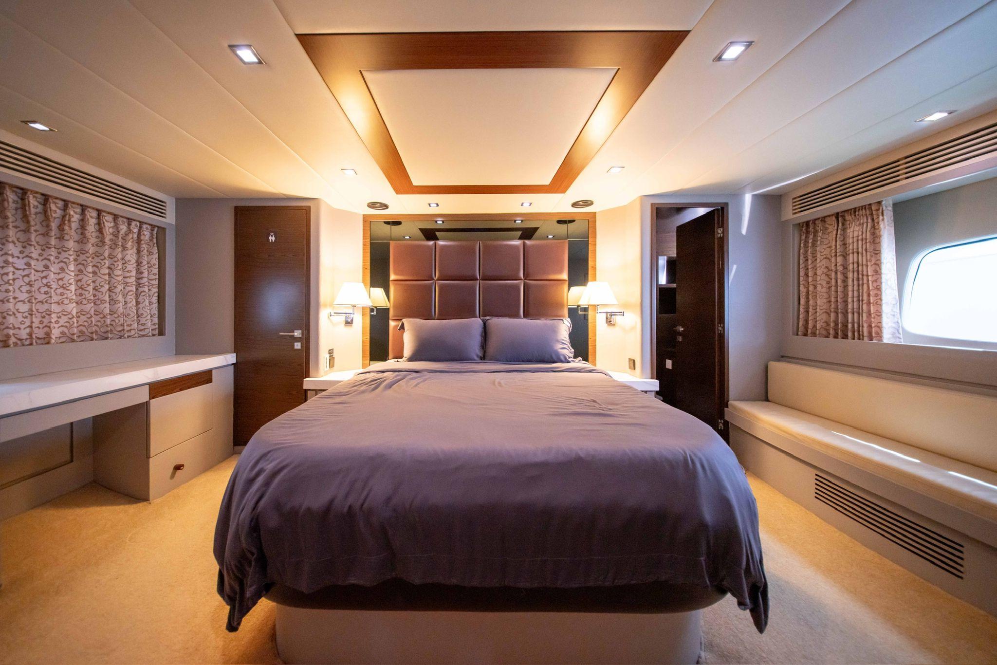 Luxurious bedroom interior on a 2011 Ruby 68 yacht, featuring elegant design and cozy ambiance.