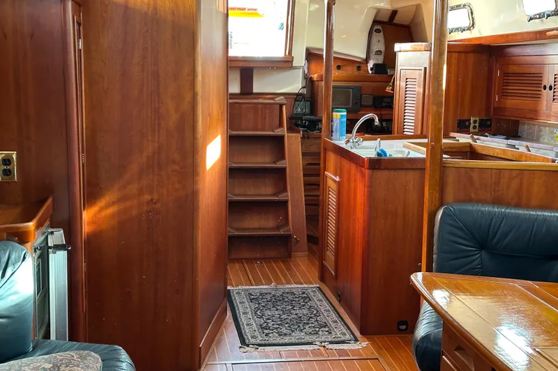 Braveheart Yacht Photos Pics Interior of a 1999 Tartan 4600 yacht with wooden cabinetry and seating area.