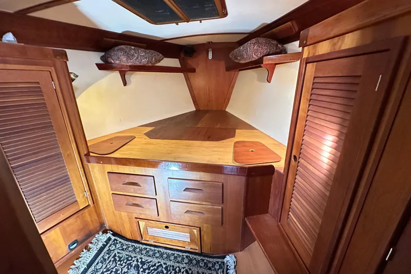 Braveheart Yacht Photos Pics Cozy wooden interior of a 1999 Tartan 4600 sailboat cabin with storage and shelves.