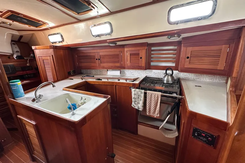Braveheart Yacht Photos Pics 1999 Tartan 4600 yacht kitchen with wooden cabinetry and modern appliances.
