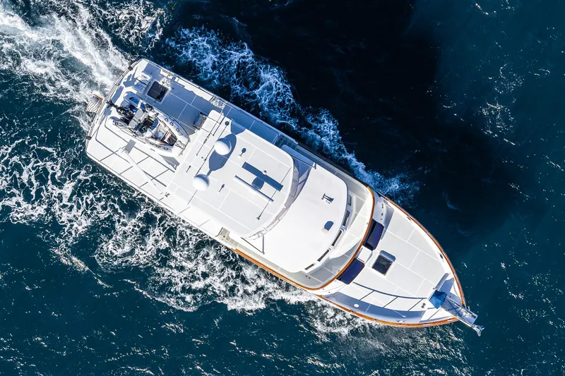 Flyin Low Yacht Photos Pics Aerial view of 2007 DeFever 56 yacht cruising through blue ocean waters.