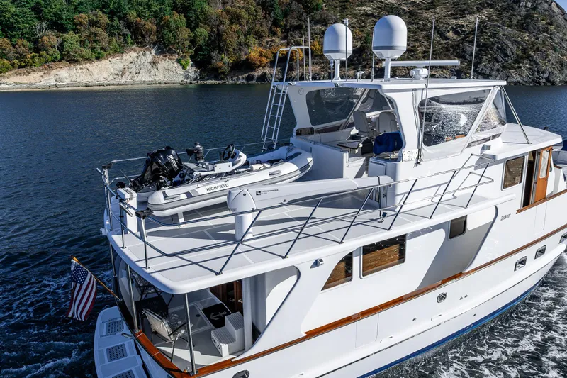 Flyin Low Yacht Photos Pics 2007 DeFever 56 yacht cruising on scenic waterway with lush green hills.