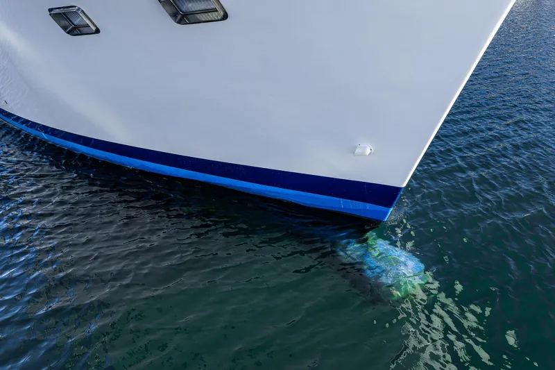 Flyin Low Yacht Photos Pics Bow of 2007 DeFever 56 yacht in water, showcasing sleek design and blue accents.