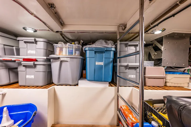 Flyin Low Yacht Photos Pics Storage area on a 2007 DeFever 56 yacht with organized plastic bins and metal ladder.