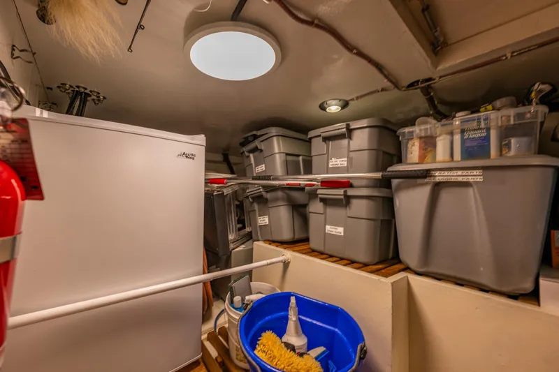 Flyin Low Yacht Photos Pics Storage area in a 2007 DeFever 56 yacht with organized bins and cleaning supplies.
