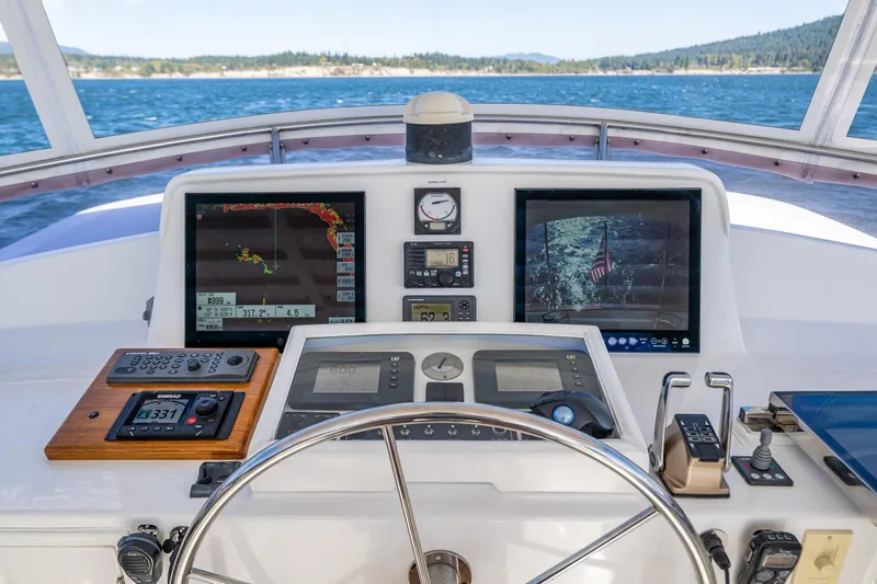 Flyin Low Yacht Photos Pics Helm of 2007 DeFever 56 yacht with navigation screens and controls, overlooking the ocean.