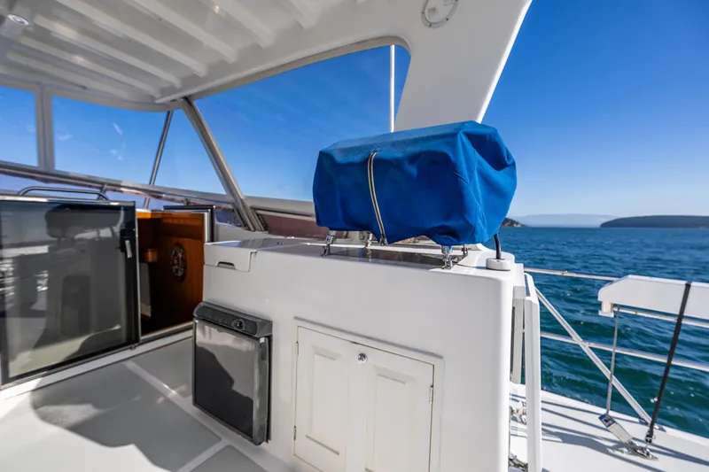 Flyin Low Yacht Photos Pics 2007 DeFever 56 yacht deck with blue cover, ocean view, and clear sky.