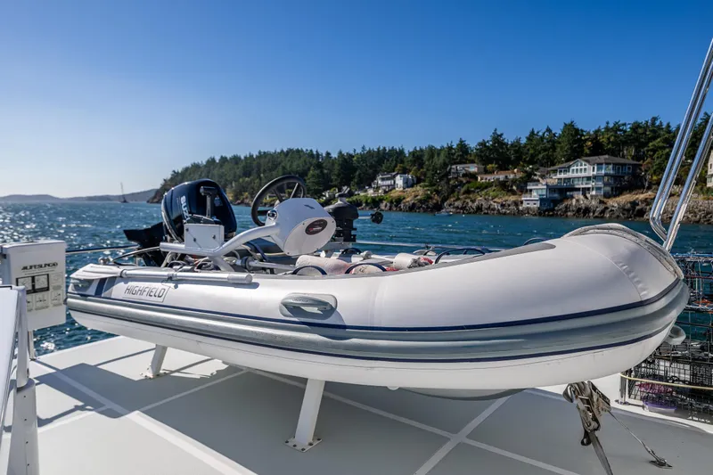 Flyin Low Yacht Photos Pics A Highfield inflatable boat on a 2007 DeFever 56 yacht, with scenic coastal background.
