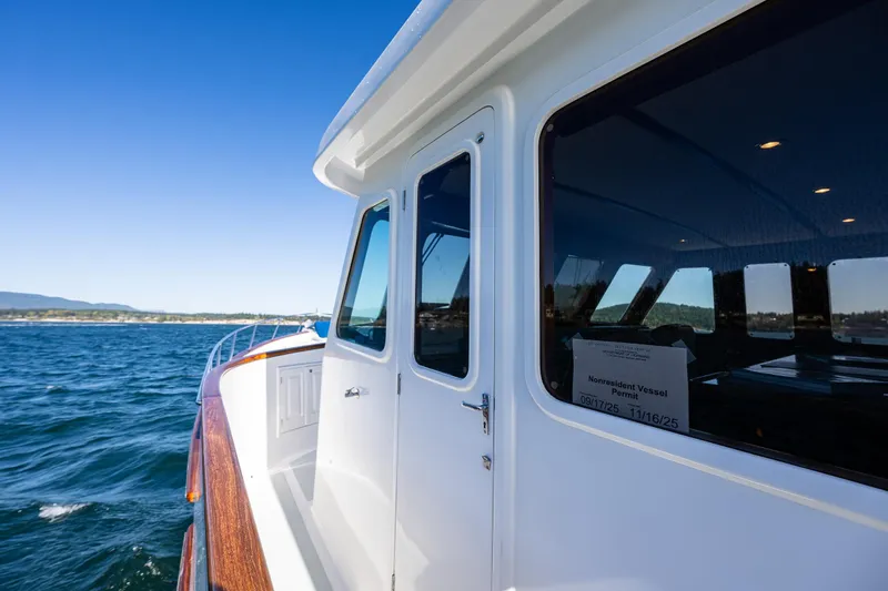 Flyin Low Yacht Photos Pics 2007 DeFever 56 yacht cruising on open water under clear blue skies.